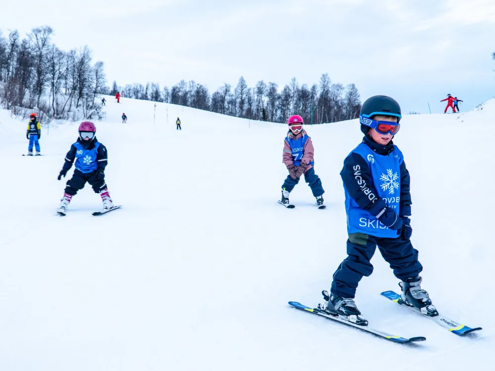 Barn lærer å bremse skiene.